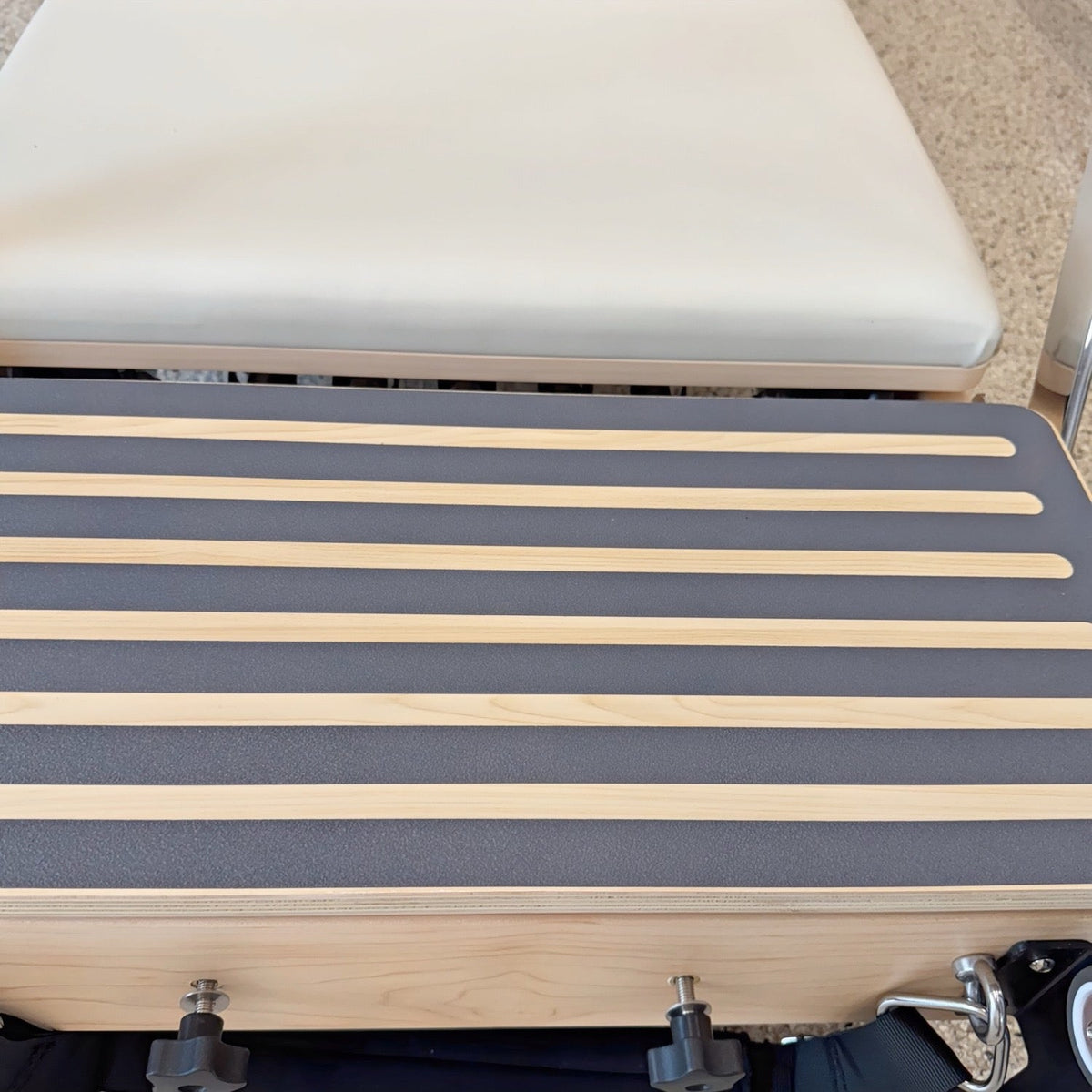 Bamboo massage table with gray padding and wooden slats for comfort.