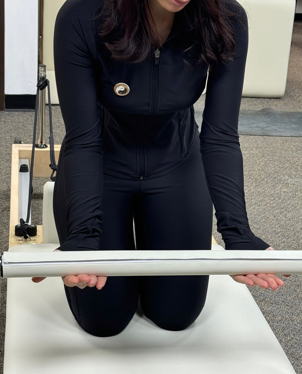 Pilates reformer exercise equipment with a user demonstrating a workout position.