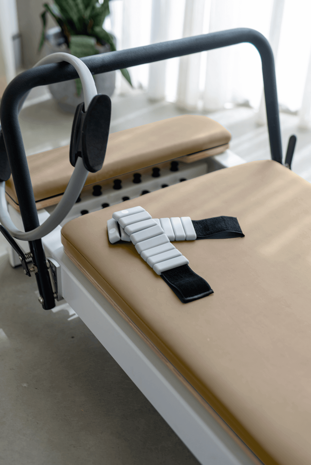 Reformer Pilates machine with adjustable straps and padded surface for comfort.