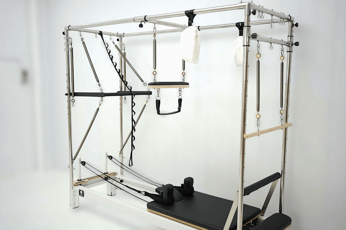 Pilates reformer with adjustable straps and a padded platform for versatile workouts.