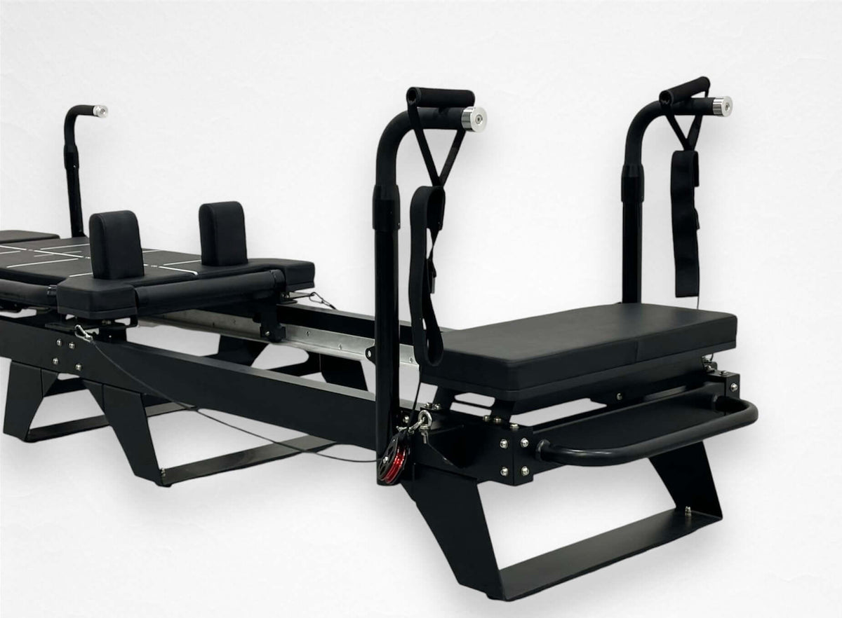 Reformer Pilates machine with adjustable straps and padded seats for effective workouts.