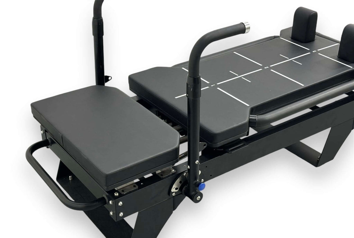 Reformer Pilates machine with adjustable platform and padded supports for comfortable workouts.