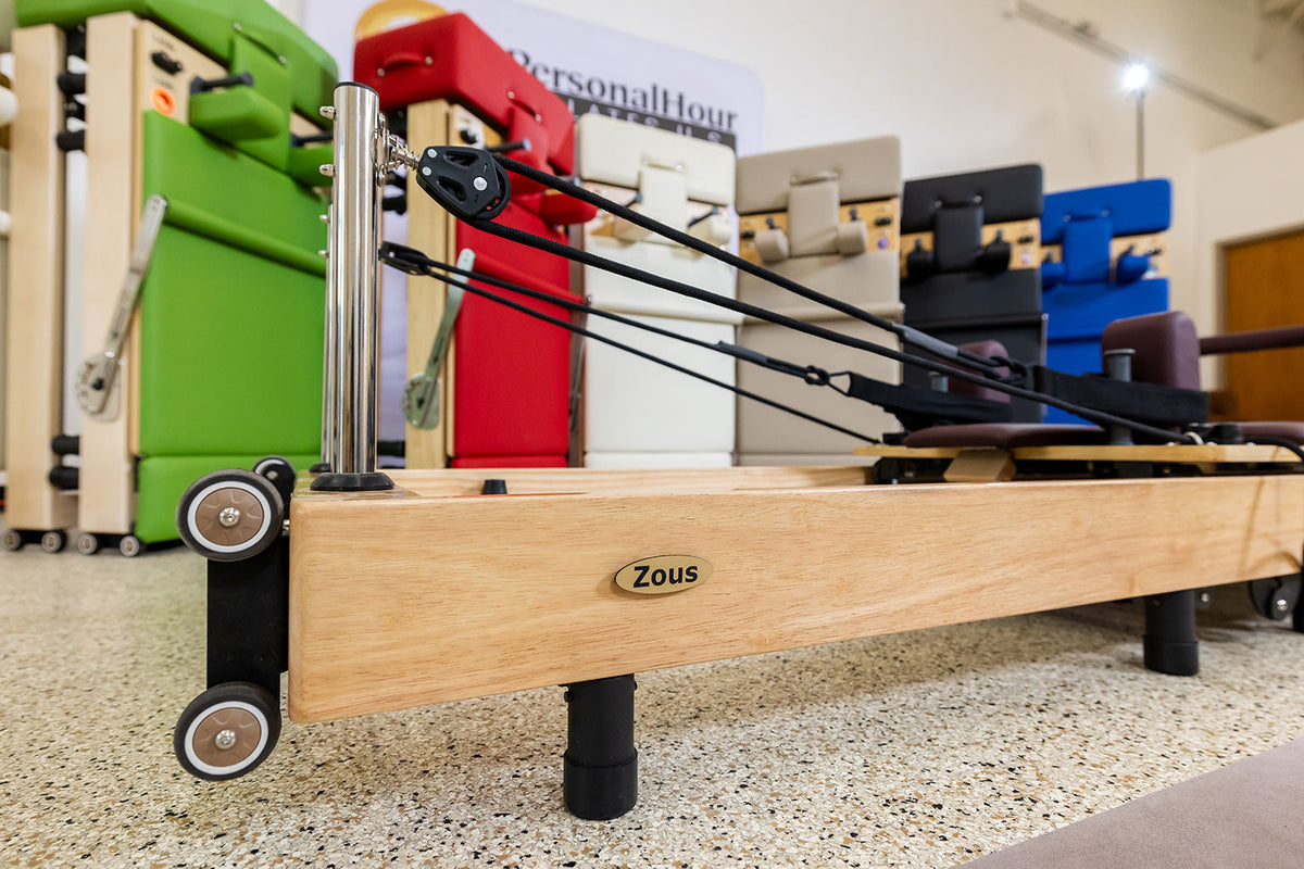 Zous rowing machine featuring a wooden frame and adjustable resistance for effective workouts.