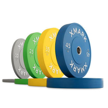 XMark weight plates in various colors and weights, including 10, 25, 35, and 45 lbs.