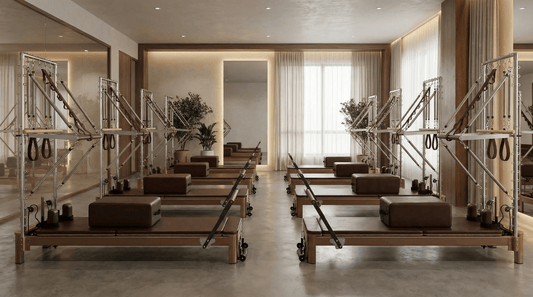 Pilates reformer machines arranged in a modern studio with natural light.