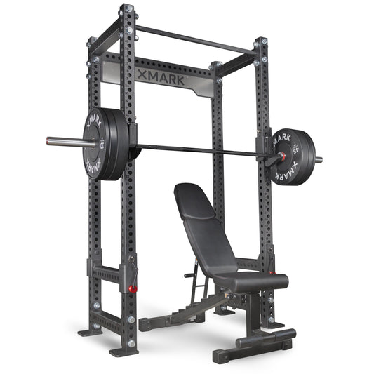 XMark power rack with adjustable bench and weight plates for strength training.