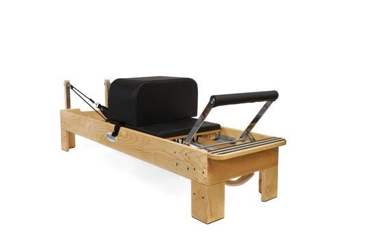 Pilates reformer with wooden frame and black padded carriage for effective workouts.