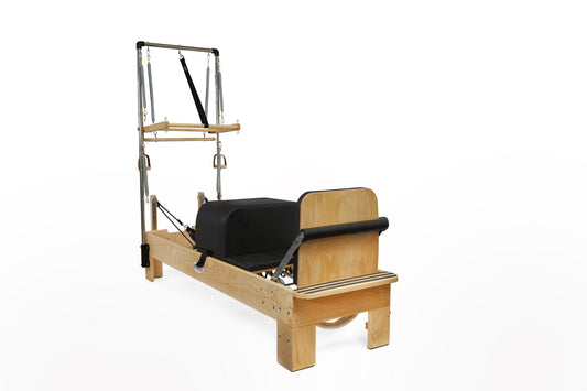 Pilates reformer with wooden frame and black padded carriage for effective workouts.