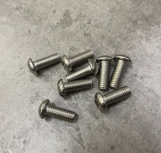 Stainless steel screws, durable and corrosion-resistant, arranged on a gray surface.